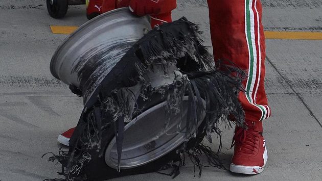 Mechanik stáje Ferrari s rozcupovanou pneumatikou z vozu Felipeho Massy. Mechanik stáje Ferrari s rozcupovanou pneumatikou z vozu Felipeho Massy.