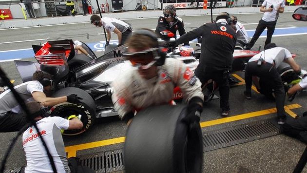 Jenson Button ze stáje McLaren u mechaniků při výměně pneumatik. Jenson Button ze stáje McLaren u mechaniků při výměně pneumatik.