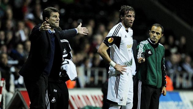 Kouč Swansea Michael Laudrup (zcela vlevo) posílá zpět do hry kanonýra Michua. Kouč Swansea Michael Laudrup (zcela vlevo) posílá zpět do hry kanonýra Michua.