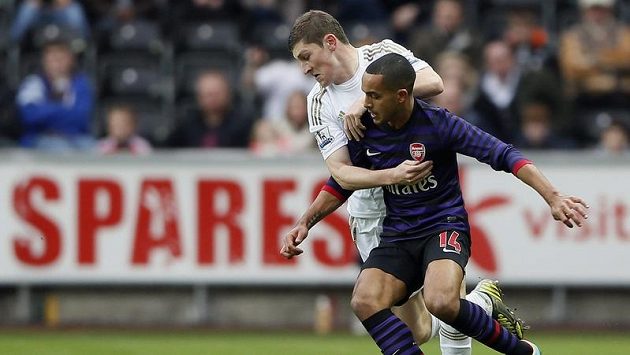 Útočník Arsenalu Theo Walcott (vpředu) bojuje o míč s Benem Daviesem ze Swansea. Útočník Arsenalu Theo Walcott (vpředu) bojuje o míč s Benem Daviesem ze Swansea.