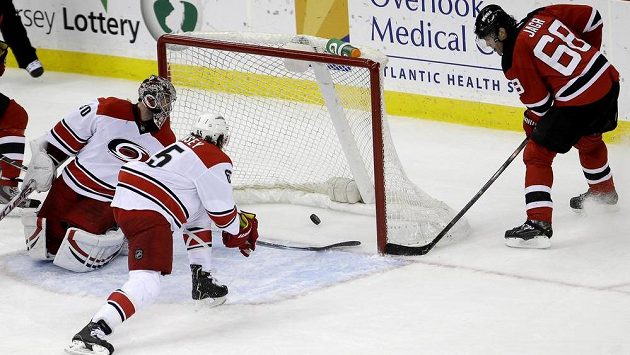 Útočník New Jersey Jaromír Jágr překonává gólmana Caroliny Cama Warda. Nezabránil mu v tom ani obránce Ron Hainsey. Útočník New Jersey Jaromír Jágr překonává gólmana Caroliny Cama Warda. Nezabránil mu v tom ani obránce Ron Hainsey.