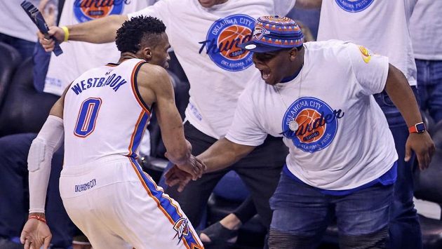 Basketbalista týmu Oklahoma City Thunder Russell Westbrook se raduje s fanouškem během duelu s Golden State Warriors. Basketbalista týmu Oklahoma City Thunder Russell Westbrook se raduje s fanouškem během duelu s Golden State Warriors.