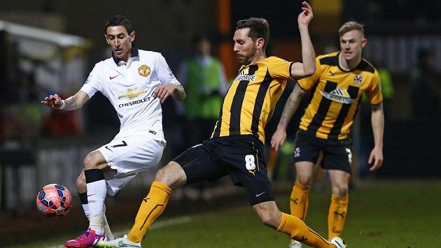 Záložník Manchesteru United Ángel Di María (vlevo) se snaží přejít s míčem přes Toma Championa z Cambridge United. Záložník Manchesteru United Ángel Di María (vlevo) se snaží přejít s míčem přes Toma Championa z Cambridge United.