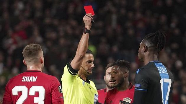 Rozhodčí Serdar Gozubuyuk dává žlutou kartu Simonu Delimu z Brugg v odvetě s Manchesterem United. Rozhodčí Serdar Gozubuyuk dává žlutou kartu Simonu Delimu z Brugg v odvetě s Manchesterem United.