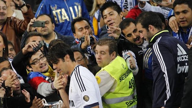 Brazilský fotbalista Kaká jde kolem jásajících fanoušků přebrat trfej pro vítěze. Brazilský fotbalista Kaká jde kolem jásajících fanoušků přebrat trfej pro vítěze.