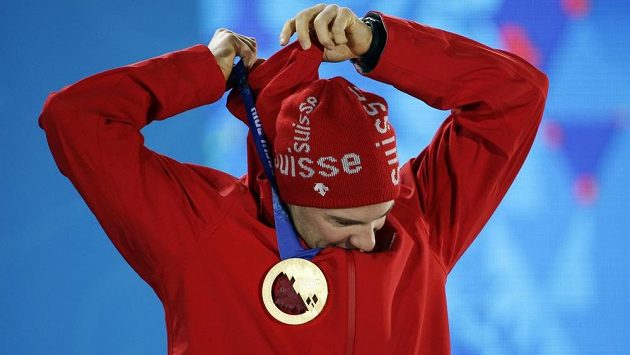 Švýcarský běžec na lyžích Dario Cologna pózuje se zlatou medailí ze závodu na 15 km klasicky. Švýcarský běžec na lyžích Dario Cologna pózuje se zlatou medailí ze závodu na 15 km klasicky.