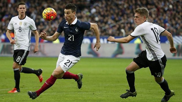 Francouz Laurent Koscielny (uprostřed) v akci s Matthiasem Ginterem (vpravo) z Německa. Francouz Laurent Koscielny (uprostřed) v akci s Matthiasem Ginterem (vpravo) z Německa.