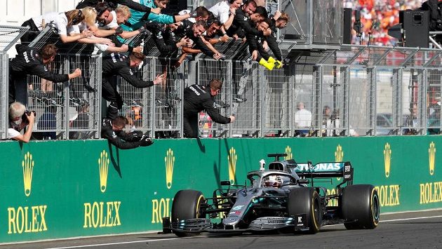 Jezdec Mercedesu Lewis Hamilton a jeho tým oslavují triumf ve Velké ceně Maďarska. Jezdec Mercedesu Lewis Hamilton a jeho tým oslavují triumf ve Velké ceně Maďarska.