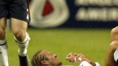 Kapitán anglické reprezentace David Beckham se v bolestivé grimase drží za zlomenou ruku. Kapitán anglické reprezentace David Beckham se v bolestivé grimase drží za zlomenou ruku.