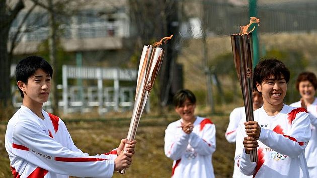 Štafetu nesli i fotbalistka Azusa Iwašimizuová (vpravo) a student Asato Owada. Štafetu nesli i fotbalistka Azusa Iwašimizuová (vpravo) a student Asato Owada.