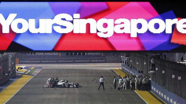 Pořadatelé tlačí vůz Nika Rosberga zpět do boxové uličky poté, co německý pilot Mercedesu během zahřívacího kola Velké ceny Singapuru kvůli problémům s řazením zůstal stát na trati. Pořadatelé tlačí vůz Nika Rosberga zpět do boxové uličky poté, co německý pilot Mercedesu během zahřívacího kola Velké ceny Singapuru kvůli problémům s řazením zůstal stát na trati.