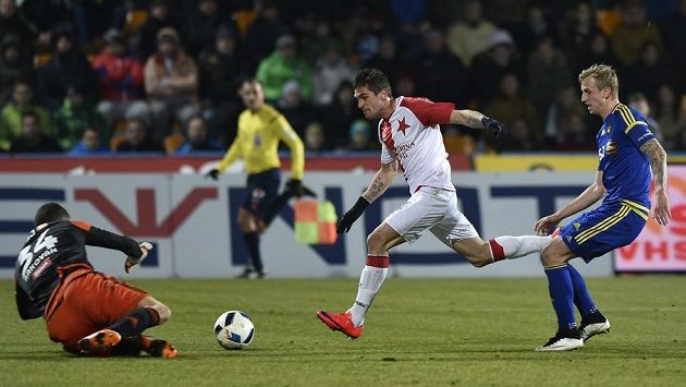 Jihlavský brankář Matej Rakovan chytá střelu záložníka Slavie Miljana Vukadinoviče. Vpravo je obránce Lukáš Kryštůfek. Jihlavský brankář Matej Rakovan chytá střelu záložníka Slavie Miljana Vukadinoviče. Vpravo je obránce Lukáš Kryštůfek.