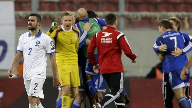 Řek Giannis Maniatis opouští hřiště, na kterém právě hráči Faerských ostrovů oslavují historické vítězství. Řek Giannis Maniatis opouští hřiště, na kterém právě hráči Faerských ostrovů oslavují historické vítězství.
