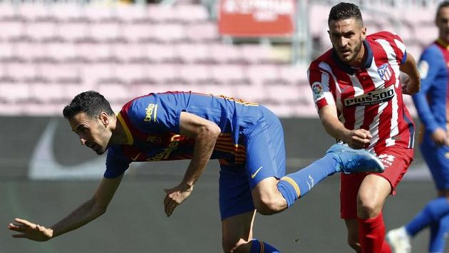 Fotbalista Barcelony Sergio Busquets (vlevo) bojuje o míč s hráčem Atlétika Madrid Koke. Fotbalista Barcelony Sergio Busquets (vlevo) bojuje o míč s hráčem Atlétika Madrid Koke.
