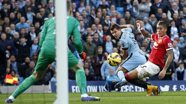 Argentinec Marcos Rojo z Manchesteru United (vpravo) se snaží zastavit střelu svého krajana Sergia Agüera z konkurenčního Manchesteru City. Argentinec Marcos Rojo z Manchesteru United (vpravo) se snaží zastavit střelu svého krajana Sergia Agüera z konkurenčního Manchesteru City.