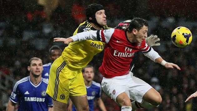Brankář Petr Čech vyráží míč před dotírajícím Mesutem Özilem z Arsenalu. Brankář Petr Čech vyráží míč před dotírajícím Mesutem Özilem z Arsenalu.
