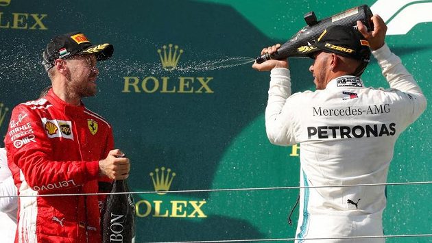 Lewis Hamilton (vpravo) kropí na stupních vítězů Sebastiana Vettela. Lewis Hamilton (vpravo) kropí na stupních vítězů Sebastiana Vettela.