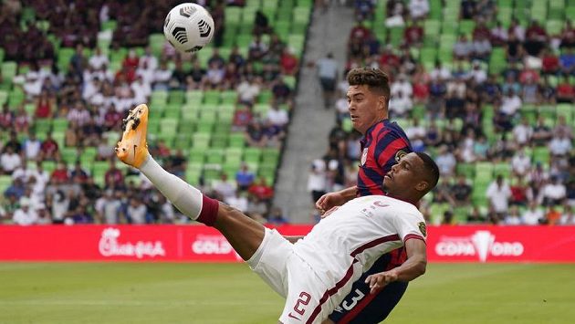 Obránce Kataru Pedro Miguel v souboji o míč s útočníkem USA Matthewem Hoppem. Obránce Kataru Pedro Miguel v souboji o míč s útočníkem USA Matthewem Hoppem.