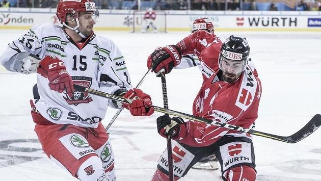 Blaž Gregorc (vlevo) z Hradce bojuje o puk s Brandonem Hickeym z kanadského výběru během zápasu na Spengler Cupu - ilustrační snímek. Blaž Gregorc (vlevo) z Hradce bojuje o puk s Brandonem Hickeym z kanadského výběru během zápasu na Spengler Cupu - ilustrační snímek.