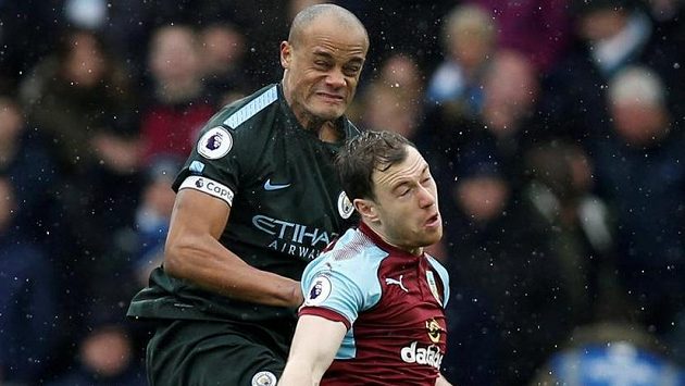 Vincent Kompany (vlevo) z Manchesteru City v hlavičkovém souboji s Ashleym Barnesem z Burnley. Vincent Kompany (vlevo) z Manchesteru City v hlavičkovém souboji s Ashleym Barnesem z Burnley.