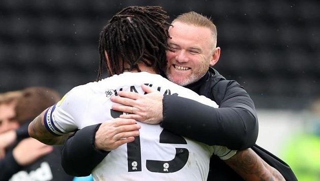 Trenér Wayne Rooney slaví s fotbalistou Colinem Kazim-Richardsem, Derby se po remíze 3:3 s Sheffieldem zachránilo v druhé anglické lize. Trenér Wayne Rooney slaví s fotbalistou Colinem Kazim-Richardsem, Derby se po remíze 3:3 s Sheffieldem zachránilo v druhé anglické lize.