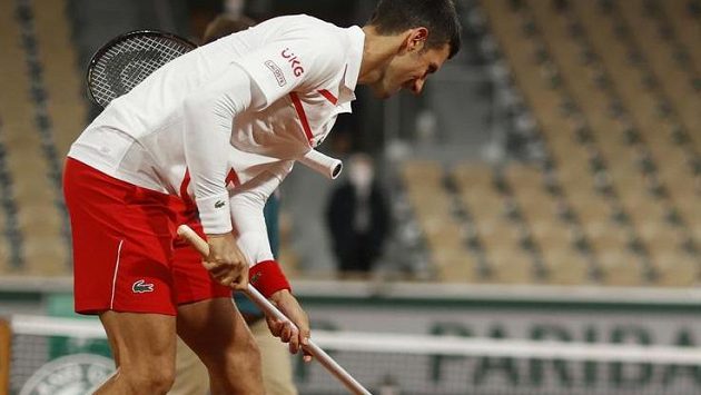 Novak Djokovič upravuje kurt před dalším pokračováním zápasu Novak Djokovič upravuje kurt před dalším pokračováním zápasu