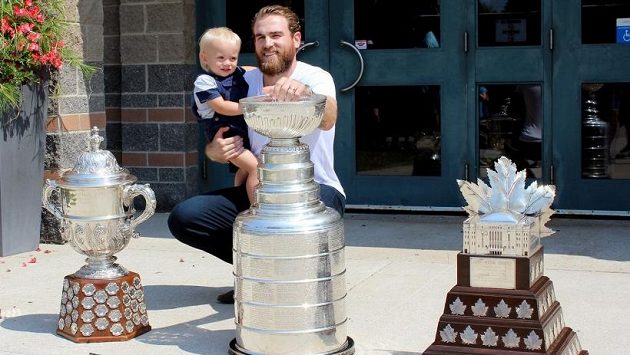 Hokejista Ryan O'Reilly s ročním synem a trofejemi z uplynulé sezony. Hokejista Ryan O'Reilly s ročním synem a trofejemi z uplynulé sezony.