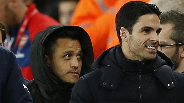 Alexis Sánchez sledoval šlágr proti Manchesteru City v kapuci jen z lavičky. Vpravo je jeho spoluhráč z Arsenalu Mikel Arteta. Alexis Sánchez sledoval šlágr proti Manchesteru City v kapuci jen z lavičky. Vpravo je jeho spoluhráč z Arsenalu Mikel Arteta.