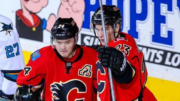 Jiří Hudler (24) z Calgary slaví gól proti San Jose se Seanem Monahanem (23). Jiří Hudler (24) z Calgary slaví gól proti San Jose se Seanem Monahanem (23).