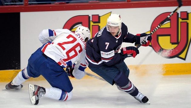 Francouz Charles Bertrand (vlevo) se snaží zastavit Alexe Goligoskiho z USA v úvodním utkání MS v hokeji. 